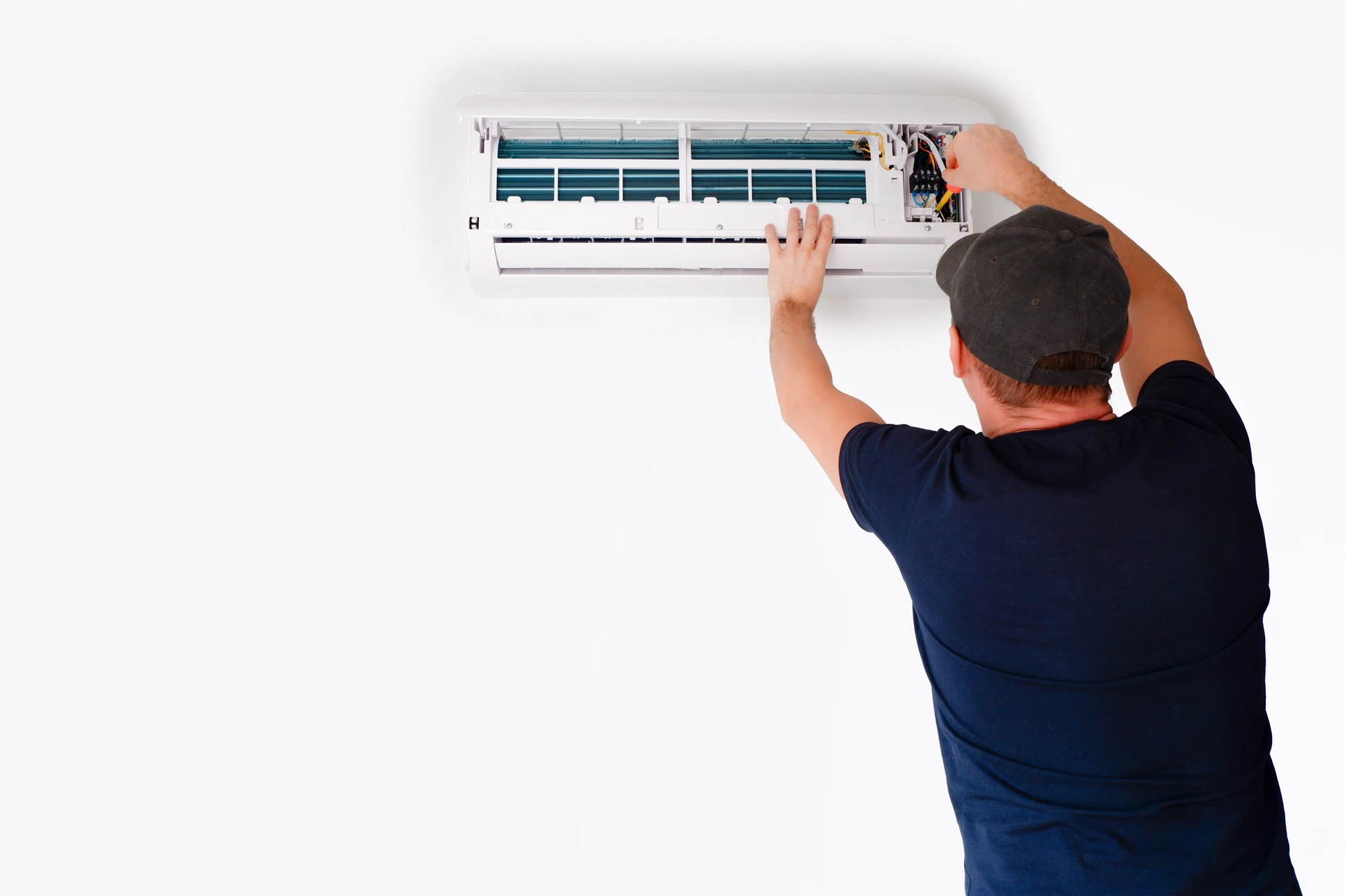 Technicien en climatisation effectuant la maintenance d'une unité murale intérieure