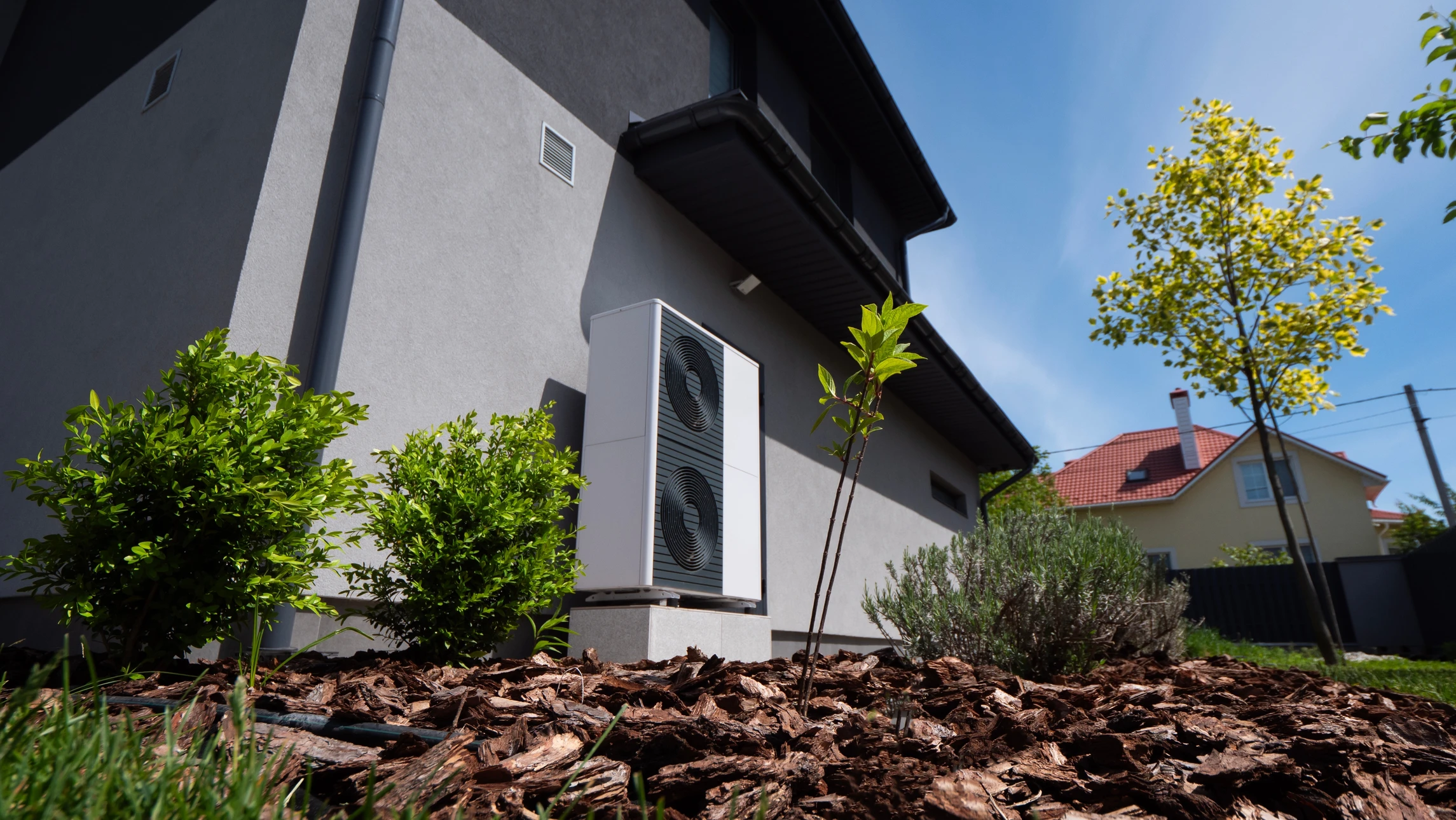 Technicien en uniforme bleu effectuant la maintenance d'un climatiseur mural split