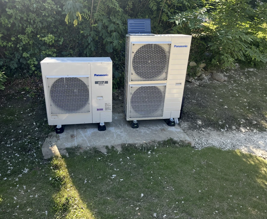 Ouvrier en casquette installant un support m&eacute;tallique de climatisation sur mur int&eacute;rieur