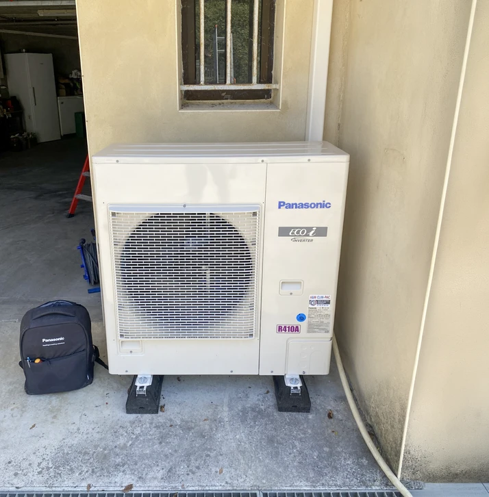 Intérieur d'un chalet en bois avec mezzanine, poutre apparente et conduit de poêle noir